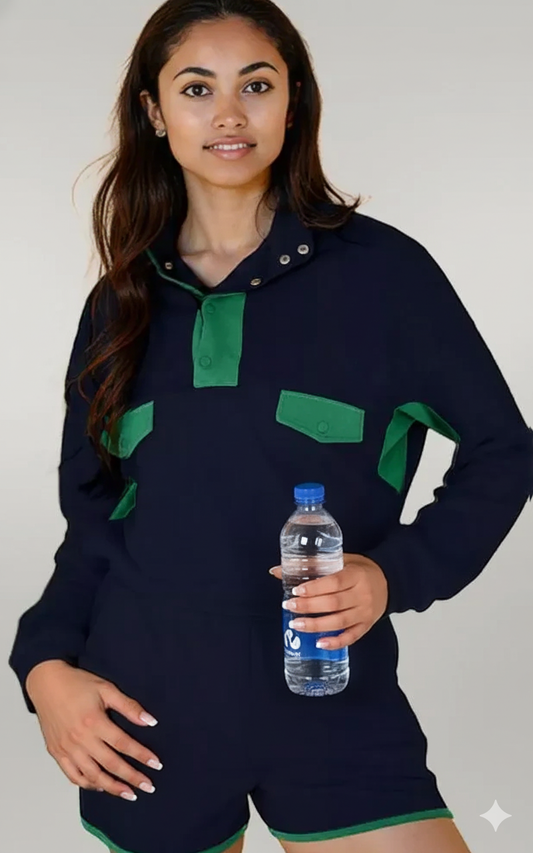 Person wearing a navy blue outfit with green accents, holding a water bottle.